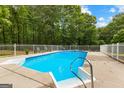 Sparkling in-ground pool with safety fence and patio seating area, perfect for relaxation at 607 Lees Mill Rd, Fayetteville, GA 30214