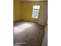 Empty bedroom with carpeted floors, a window providing natural light, and a closet at 115 Lakeview Dr, Stockbridge, GA 30281