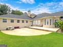 Backyard view featuring a patio, built-in seating, and neutral stucco exterior at 335 Canvasback Trl, Locust Grove, GA 30248