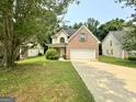 Traditional brick-accented home featuring an attached two-car garage and a well-manicured front lawn at 105 Avonwood Cir, Locust Grove, GA 30248