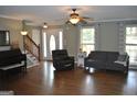 Comfortable living room featuring hardwood floors, neutral paint, and a cozy seating arrangement at 500 Hayfield Ct, Locust Grove, GA 30248