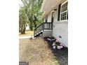 Charming home exterior with brick accents and fresh landscaping featuring colorful flowers and dark mulch at 1101 White Oak Sw Ave, Atlanta, GA 30310