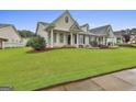 Inviting home exterior features a lush green lawn, mature landscaping, and charming architectural details at 1025 Pinehurst Dr, Peachtree City, GA 30269