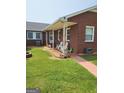 Relaxing covered porch with rocking chairs on brick home exterior at 619 E College St, Bowdon, GA 30108