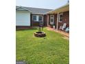 Backyard with a brick fire pit and covered porch at 619 E College St, Bowdon, GA 30108