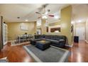 Spacious living room featuring hardwood floors, a large grey sectional sofa, a fireplace, and an open dining area at 6403 Heritage Run, Morrow, GA 30260