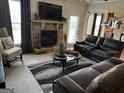 Cozy living room with a stone fireplace, plush leather seating, and a comfortable atmosphere at 860 Nevis Way, Mcdonough, GA 30253