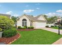 Well-manicured lawn and landscaping accent this home with an attached two-car garage at 412 Rock Creek Dr, Peachtree City, GA 30269