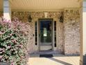Inviting front entrance showcasing decorative shrubbery, sconce lighting, and a glass front door at 137 Nobility Ln, Mcdonough, GA 30252
