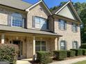 Beautiful brick home with well-maintained landscaping and a cozy front porch area at 137 Nobility Ln, Mcdonough, GA 30252
