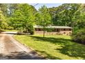 Long driveway leading to a brick home with lush front yard and surrounded by mature trees at 160 Pine Trail Rd, Fayetteville, GA 30214