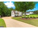 Long driveway leading to a two-story home with an attached garage, beautiful landscaping, and mature trees at 355 Sturgess Run, Sharpsburg, GA 30277