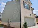 Side view of a modern home with gray wood and light brick, complemented by dark window shutters at 13 Butternut Way # 120B, Auburn, GA 30011