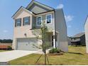 New two-story home with a two car garage, brick, siding, and newly installed landscaping at 42 Avian Way # 128B, Auburn, GA 30011