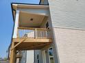 Newly built rear deck supported by wooden beams with beige vinyl siding and white brick at 42 Avian Way # 128B, Auburn, GA 30011