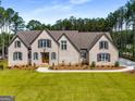 Light brick two-story home with manicured lawn and professional landscaping at 100 Regina Ct, Fayetteville, GA 30215