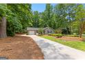 Cozy single-story house with landscaped front yard and driveway, surrounded by mature trees at 810 Bedford Park, Peachtree City, GA 30269