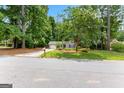 View of a well-landscaped front yard with a cozy home surrounded by lush trees at 810 Bedford Park, Peachtree City, GA 30269