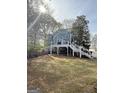 Spacious backyard featuring a deck, patio area, and beautiful landscaping with mature trees and water views at 107 Terrane Rdg, Peachtree City, GA 30269