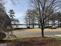 Scenic view from the property overlooking a tranquil lake, framed by trees and a well-manicured lawn at 107 Terrane Rdg, Peachtree City, GA 30269