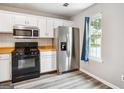 Updated kitchen featuring stainless steel appliances, ample cabinet space, and a bright window at 2049 Charter Ln, Lithonia, GA 30058