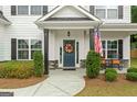 Inviting front porch with an American flag and decorative wreath on a navy blue door at 8 Saint Charles Ave, Sharpsburg, GA 30277