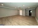 Spacious living room with stylish wood-look flooring, recessed lighting, and neutral paint at 8846 Wesley Pl, Jonesboro, GA 30238