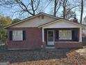 Charming brick home with a covered front porch and black shutters, surrounded by trees at 953 South Ave, Forest Park, GA 30297