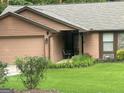 Close-up of home with a manicured green lawn and mature landscaping at 6884 Shangrila Way, Riverdale, GA 30296