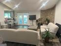 Bright living room with stone accent wall, opening to a kitchen and featuring outdoor access at 6884 Shangrila Way, Riverdale, GA 30296