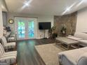 Relaxing living room with a stone accent wall, access to the pool area, and stylish furnishings at 6884 Shangrila Way, Riverdale, GA 30296