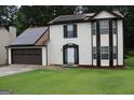 Two-story home with neutral siding, brown accents, and a solar panel array on the roof at 3255 Hunters Crossing Pt, Lithonia, GA 30038