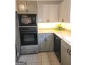 This kitchen features stainless steel appliances, neutral countertops, and plenty of natural light from window at 6340 Koweta Rd, Fairburn, GA 30213