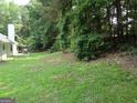 A spacious backyard with a lush lawn, mature trees, and an outdoor seating area, perfect for outdoor enjoyment at 2958 Mary Alice Trl, Loganville, GA 30052