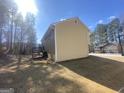 Backyard view showcasing a wooden deck and stairs, with a lush green backdrop at 6205 Littleton Dr, Union City, GA 30291