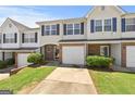 Townhome with a garage, front lawn, and a brick facade, all under a clear blue sky at 695 Georgetown Ct, Jonesboro, GA 30236