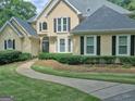 Beautiful home with a winding sidewalk, manicured landscaping, and mature trees at 307 Worthing Ln, Mcdonough, GA 30253