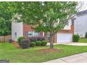 Side exterior shot with brick, vinyl siding, landscaping, and large tree at 2093 Parador Bnd, Mcdonough, GA 30253