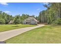 Expansive home situated on a large lot with mature trees and a long driveway, providing privacy and curb appeal at 33 Vinery Ct, Sharpsburg, GA 30277