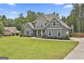 Attractive home with a stone and siding exterior, complemented by a lush green lawn and landscaped front yard at 33 Vinery Ct, Sharpsburg, GA 30277