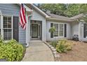 Inviting front entrance with a decorative glass door, sidelights, and an American flag proudly displayed at 505 Bracken Edge, Peachtree City, GA 30269