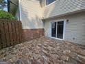 Back patio offers privacy fencing, stone flooring, and a sliding glass door to the home's interior at 292 Twiggs Cor, Peachtree City, GA 30269