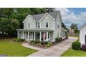 Charming two-story home features a welcoming porch, lush landscaping, and an American flag at 100 Rabbits Run, Fayetteville, GA 30214