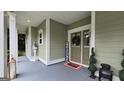 Charming covered porch features elegant columns, decor, and inviting entrance at 100 Rabbits Run, Fayetteville, GA 30214