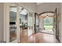 Welcoming foyer with hardwood floors, stone archway, and glass doors leading to a study at 265 Beverly Farms Dr, Sharpsburg, GA 30277