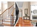 Elegant foyer showcasing hardwood floors, a staircase, and a fireplace with stone accents at 931 Hidden Falls Se Ln, Smyrna, GA 30082
