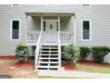 Inviting front porch with bright white stairs, railing and trimmed bushes at 3858 Trenton Dr, Snellville, GA 30039