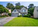 Well-maintained two-story home with a two-car garage, mature trees, and a green lawn at 2938 Cottesford Se Way, Smyrna, GA 30080