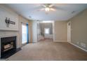 Open living area featuring a fireplace, neutral carpet, and a staircase leading upstairs at 2938 Cottesford Se Way, Smyrna, GA 30080