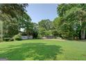 Spacious backyard with outbuildings and large trees, offering ample room for outdoor activities and storage at 315 Jewel Ln, Covington, GA 30014